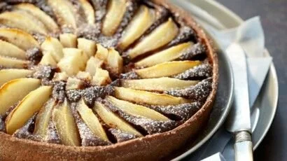 Tarte amandine poire-chocolat garnie de poires et de chocolat.